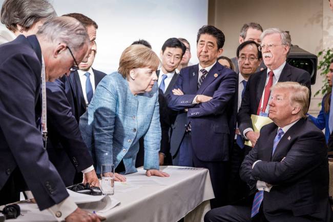 Heads Of State Attend G7 Meeting – Day Two CHARLEVOIX, CANADA - JUNE 9: In this photo provided by the German Government Press Office (BPA), German Chancellor Angela Merkel deliberates with US president Donald Trump on the sidelines of the official agenda on the second day of the G7 summit on June 9, 2018 in Charlevoix, Canada. Also pictured are (L-R) Larry Kudlow, director of the US National Economic Council, Theresa May, UK prime minister, Emmanuel Macron, French president, Angela Merkel, Yasutoshi Nishimura, Japanese deputy chief cabinet secretary, Shinzo Abe, Japan prime minister, Kazuyuki Yamazaki, Japanese senior deputy minister for foreign affairs, John Bolton, US national security adviser, and Donald Trump. Canada are hosting the leaders of the UK, Italy, the US, France, Germany and Japan for the two day summit. (Photo by Jesco Denzel /Bundesregierung via Getty Images)
