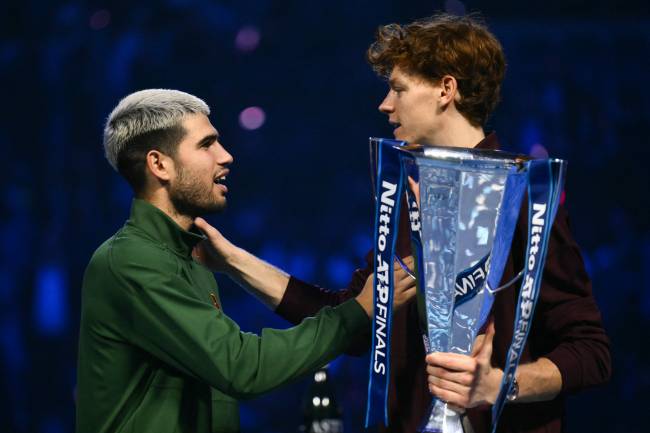 Spain's Carlos Alcaraz (L) greets Italy's Jannik Sinner during the trophy ceremony at the end of their men's single final match at the ATP Finals tennis tournament, in Turin, on November 16, 2025. (Photo by Marco BERTORELLO / AFP)