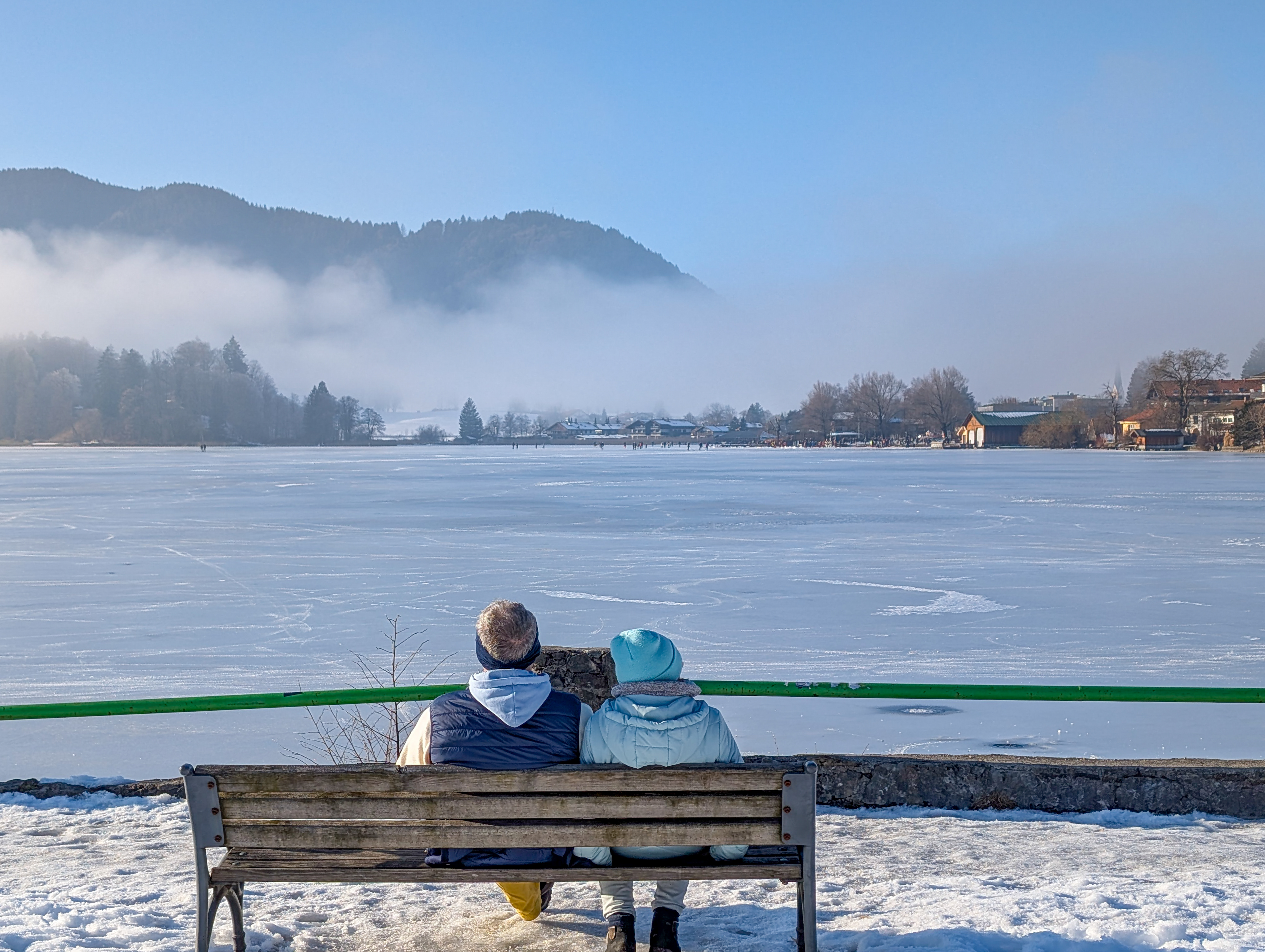 Couple At The Snowy And Frozen Edge Of Lake Schliersee In Bavaria