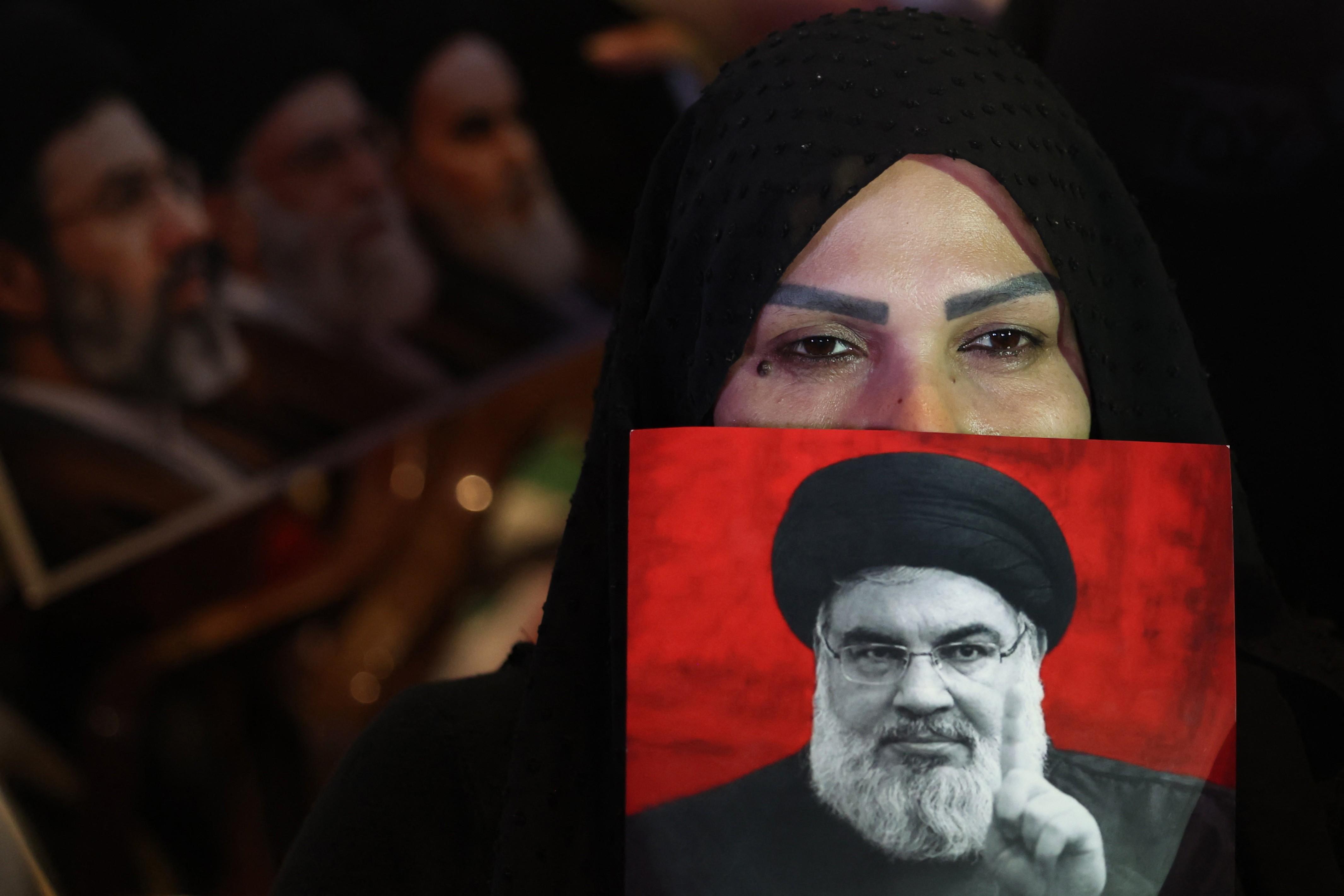 Apoiadora do Hezbollah segura cartaz de Hassan Nasrallah